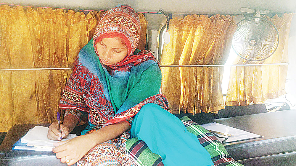 পরীক্ষা কেন্দ্র চত্বরে গতকাল অ্যাম্বুলেন্সে বসে পরীক্ষা দেন লুশি আক্তার। ছবি: প্রথম আলো