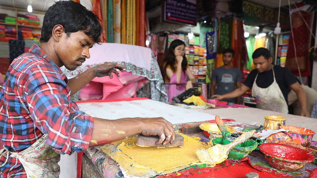 নানা রং নিয়ে কাজ করছেন এক কারিগর।