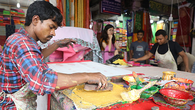 নানা রং নিয়ে কাজ করছেন এক কারিগর।