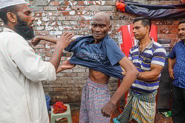 রুহুল আমিনকে জামা পরিয়ে দিচ্ছেন আওলাদ হোসেইন