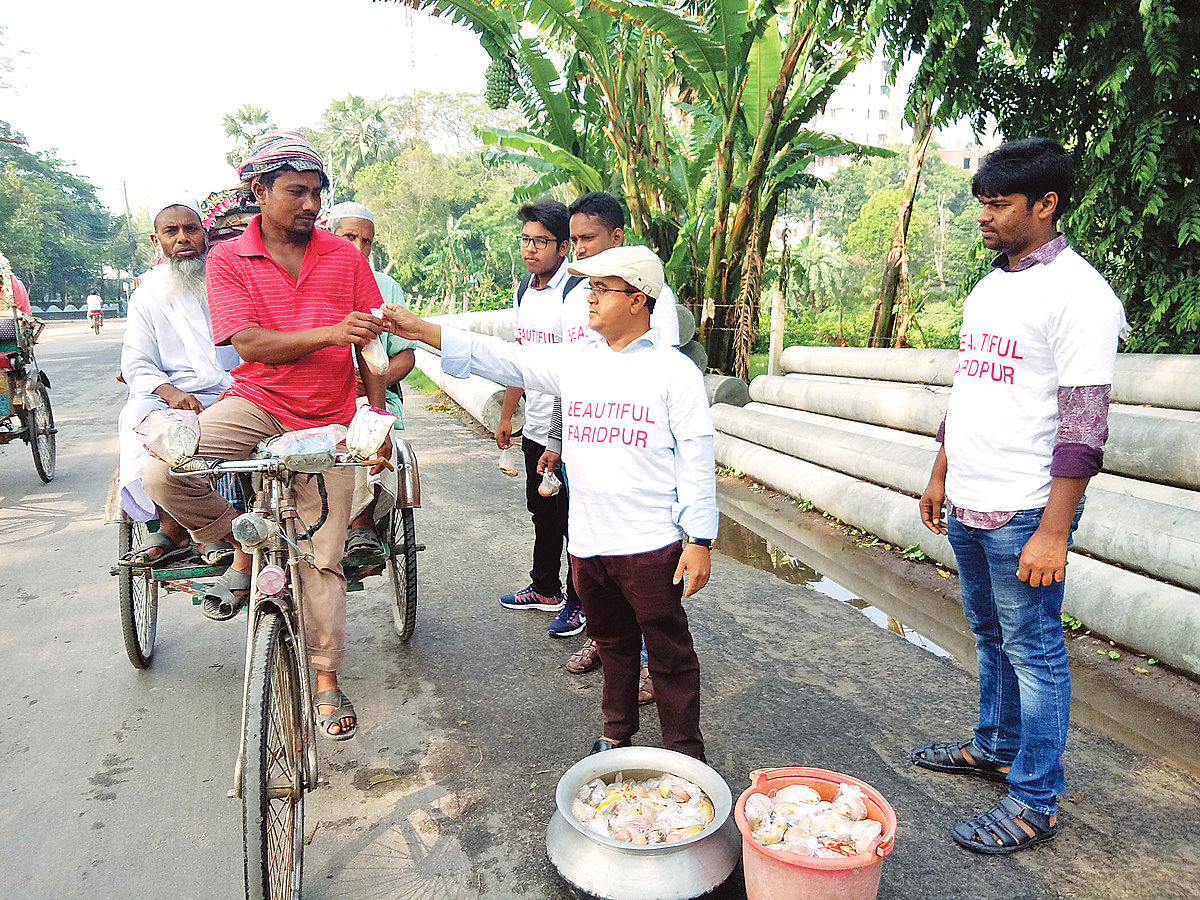 ফরিদপুর শহরের কমলাপুর এলাকায় গতকাল রিকশাচালকদের মধ্যে কলা ও ডিম বিতরণ করেন নূরুল ইসলাম। ছবি: প্রথম আলো