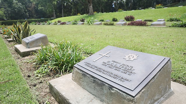 সমাধির ফলকে নাম, মৃত্যুর তারিখ ও পদবির পাশাপাশি ধর্মীয় প্রতীকও রয়েছে।