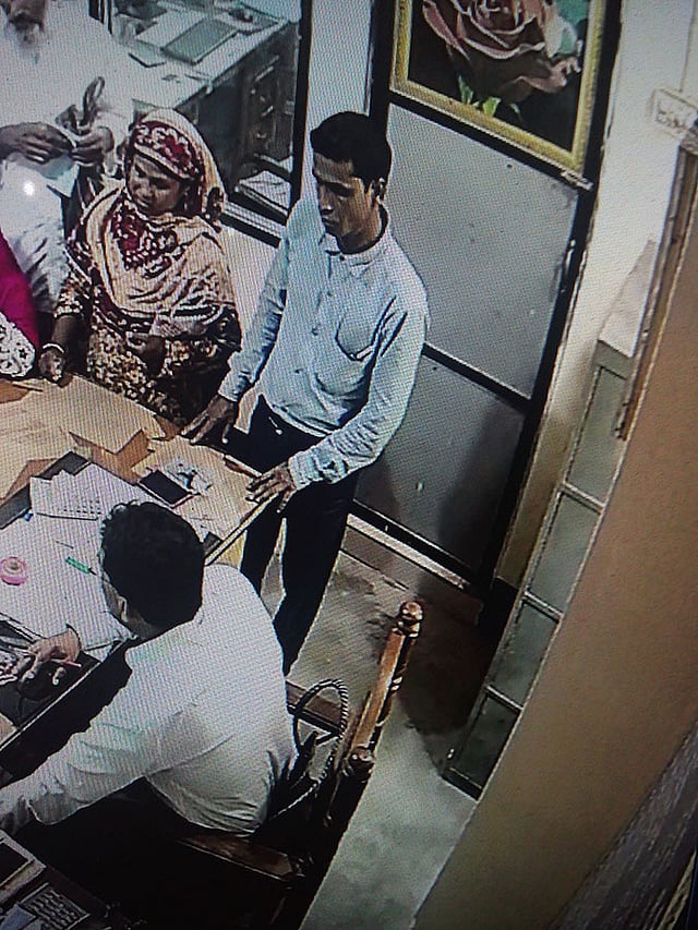 ৯৪ হাজার টাকা নিয়ে পালানো প্রতারকের (দাঁড়িয়ে থাকা ব্যক্তি) ছবি ধরা পড়েছে ব্যাংকের সিসিটিভি ফুটেজে। ছবি: সংগৃহীত