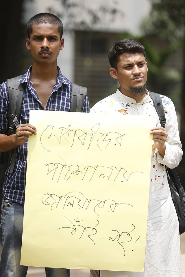 ‘মেধাবীর পাঠশালায় জালিয়াতের ঠাঁই নাই’—হাতে লেখা পোস্টার নিয়ে মানববন্ধনে দুই শিক্ষার্থী। অপরাজেয় বাংলা, ১৭ এপ্রিল। ছবি: দীপু মালাকার