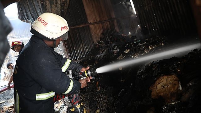 ছাইচাপা আগুনে পানি দিচ্ছেন ফায়ার সার্ভিসের এক কর্মী।