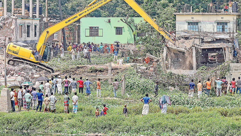 তুরাগ নদের পাড়ের অবৈধ স্থাপনা উচ্ছেদে বিআইডব্লিউটিএর অভিযান। গতকাল দুপুরে টঙ্গীর বড় দেওড়া এলাকায়। ছবি: প্রথম আলো