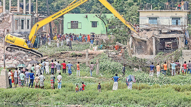 তুরাগ নদের পাড়ের অবৈধ স্থাপনা উচ্ছেদে বিআইডব্লিউটিএর অভিযান। গতকাল দুপুরে টঙ্গীর বড় দেওড়া এলাকায়।  ছবি: প্রথম আলো