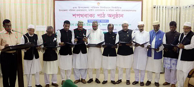 নওগাঁর ১১ উপজেলার নবনির্বাচিত চেয়ারম্যানকে শপথবাক্য পাঠ করান চ্ছেন রাজশাহী বিভাগীয় কমিশনার নূর-উর- রহমান। গতকাল নওগাঁ সার্কিট হাউস মিলনায়তনে। ছবি: প্রথম আলো