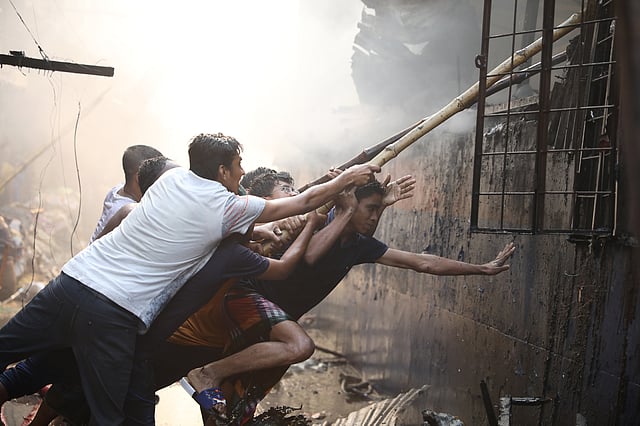 আগুন নেভানোর প্রাণপণ চেষ্টায় কয়েকজন।
