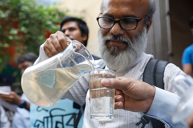 ওয়াসার পানির নমুনা দেখাচ্ছেন প্রতিবাদকারীরা। ছবি: দীপু মালাকার