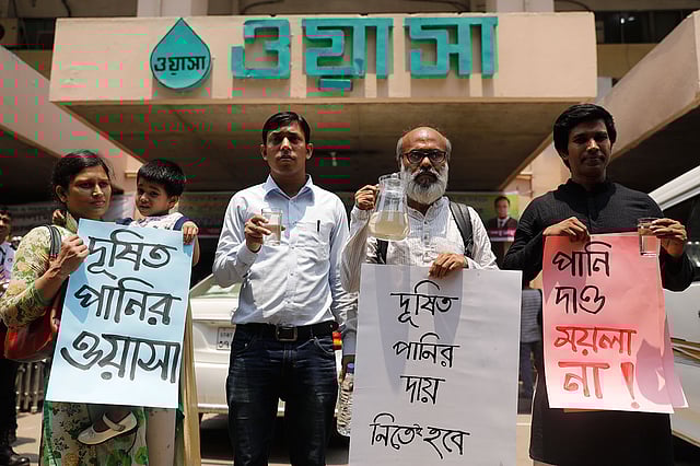 ঢাকা ওয়াসা ভবনের সামনে ওয়াসার পানি হাতে প্রতিবাদকারীরা। ছবি: দীপু মালাকার