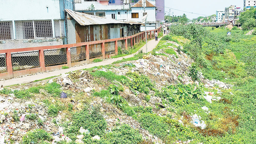 কিশোরগঞ্জের নরসুন্দা নদীর লেকওয়ের পাশে ফেলা হচ্ছে ময়লা–আবর্জনা। গত বুধবার বড়বাজারের পেছনের নরসুন্দা নদীর পাড়ে। ছবি: প্রথম আলো