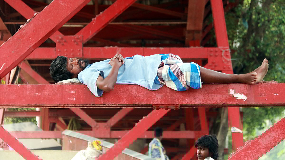সিলেটে বৈশাখের খরতাপ বেড়েই চলেছে। জনজীবনে নেমেছে স্থবিরতা। গরমে ক্লান্ত শরীর নিয়ে ব্রিজের রেলিংয়ে ঘুমিয়ে পড়েছেন এক ব্যক্তি। কিনব্রিজ, সিলেট, ২৮ এপ্রিল। ছবি: আনিস মাহমুদ