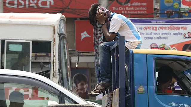 প্রখর রোদ থেকে বাঁচতে একজন গামছা দিয়ে মাথা ঢেকে রেখেছেন। গুলিস্তান এলাকা।