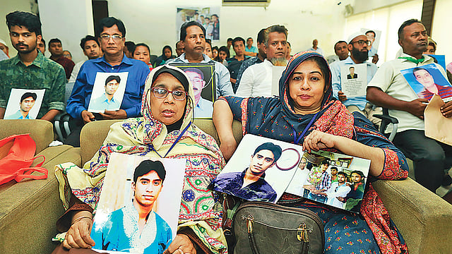 নিখোঁজ সাবেক ছাত্রলীগ নেতা শেখ মোয়াজ্জেমের ছবি নিয়ে এসেছেন তাঁর মা ছালেহা খাতুন (সামনের সারিতে বাঁয়ে)। পেছনে আরও অনেক নিখোঁজের স্বজনেরা। গতকাল প্রেসক্লাবে, গুম ও গণতন্ত্রের অব্যাহত সংকট নিয়ে আলোচনায়।  ছবি: শুভ্র কান্তি দাশ