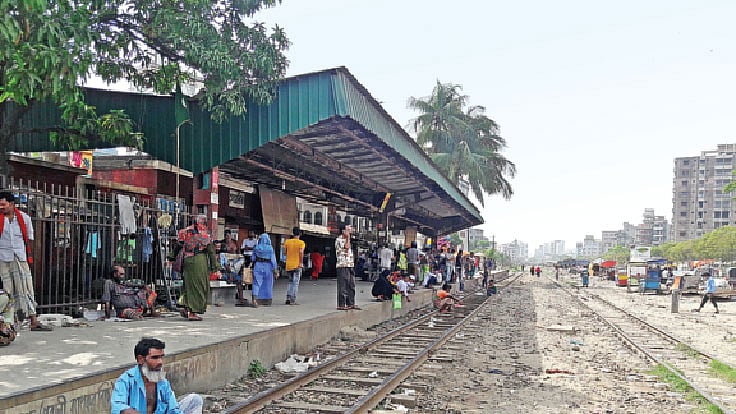 বসার জায়গা নেই, তাই প্ল্যাটফর্মের মেঝে ও রেললাইনের ওপর বসে আছেন যাত্রীরা। গত রোববার রাজধানীর গেন্ডারিয়া রেলস্টেশনে।  ছবি: প্রথম আলো