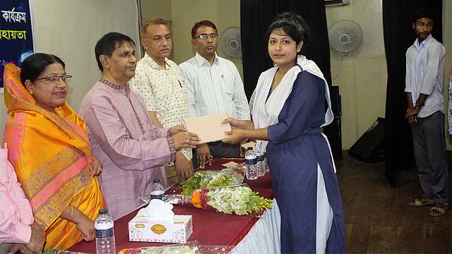 রাজবাড়ীতে ‘বিনি পয়সার ইস্কুল’-এর শিক্ষা বৃত্তি নিচ্ছে এক শিক্ষার্থী। ছবি: এজাজ আহম্মেদ