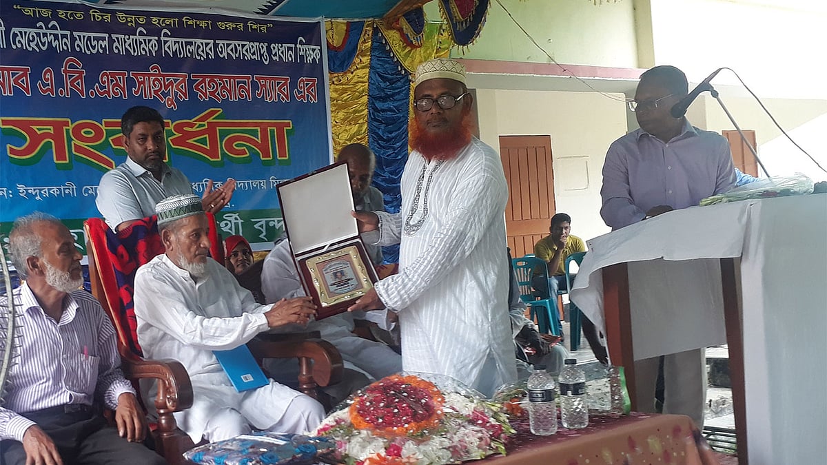 অবসরের ৪০ বছর পরে শিক্ষক সাইদুর রহমানকে ক্রেস্ট দিয়ে বিদায়ী শুভেচ্ছা জানাচ্ছেন তাঁর প্রাক্তন এক শিক্ষার্থী। ইন্দুরকানি, পিরোজপুর, ২ মে ২০১৯। ছবি: এ কে এম ফয়সাল