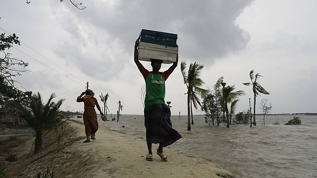 নিরাপদ জায়গায় সরে যাচ্ছে মানুষ। গোবরা, ঘাটাখালী, কয়রা, খুলনা। ছবি: শুভ্র কান্তি দাশ