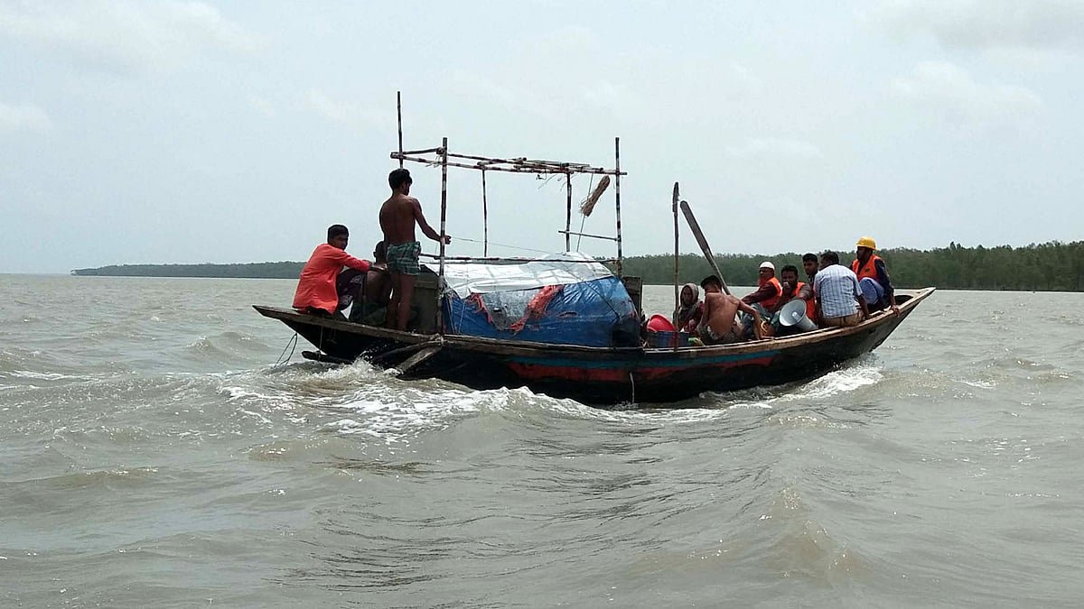 চর কাসেমের ঝুঁকিপূর্ণ এলাকার লোকজন ও গবাদিপশু নিরাপদ আশ্রয়ে নিয়ে যাচ্ছেন স্বেচ্ছাসেবকেরা। রাঙ্গাবালী, পটুয়াখালী। ছবি: প্রথম আলো