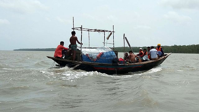 চর কাসেমের ঝুঁকিপূর্ণ এলাকার লোকজন ও গবাদিপশু নিরাপদ আশ্রয়ে নিয়ে যাচ্ছেন স্বেচ্ছাসেবকেরা। রাঙ্গাবালী, পটুয়াখালী। ছবি: প্রথম আলো