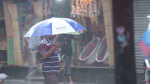 বৃষ্টির মধ্যে কর্মজীবী মানুষের ছুটে চলা। সাতমাথা, বগুড়া, ৪ মে। ছবি: সোয়েল রানা