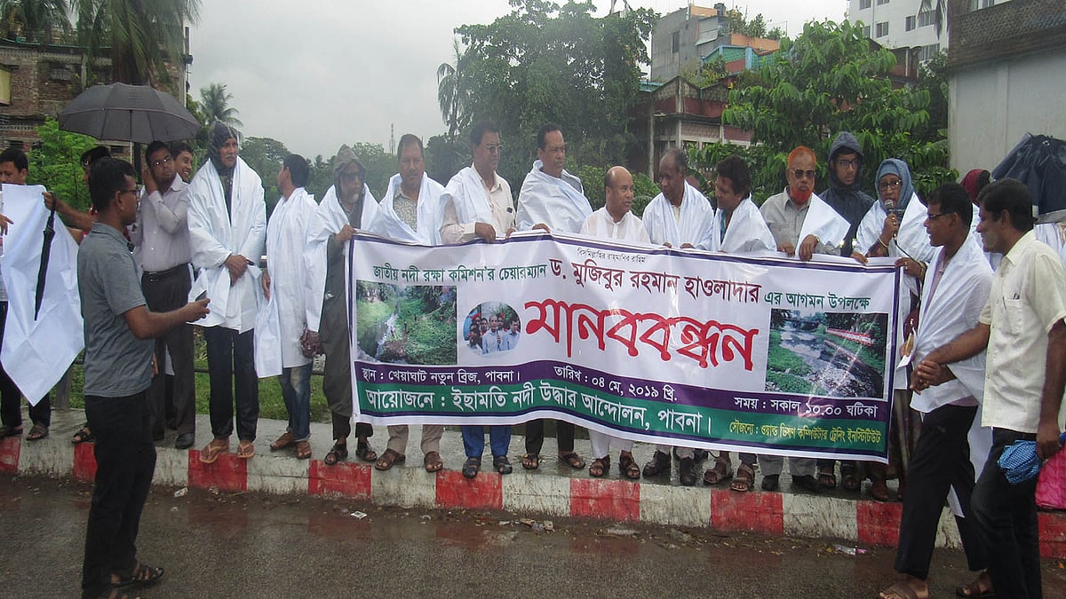 ইছামতী রক্ষা আন্দোলন কমিটির সদস্যরা পাবনা শহরের খেয়াঘাট এলাকায় কাফনের কাপড় পরে মানববন্ধন করেন। ছবি: হাসান মাহমুদ