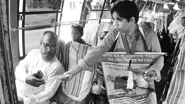 রাজশাহীতে  সড়ক দুর্ঘটনা রোধে সচেতনতামূলক লিফলেট বিতরণ করছেন সাঈদ রিমন।
