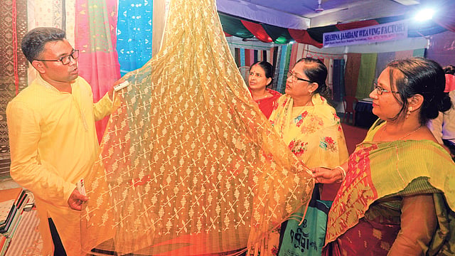 বাংলাদেশ ক্ষুদ্র ও কুটির শিল্প করপোরেশনের উদ্যোগে সপ্তাহব্যাপী জামদানি প্রদর্শনী ও মেলার শুরুর দিনে দর্শনার্থীরা শাড়ি দেখছেন। গতকাল বিকেলে জে এম সেন মিলনায়তনে।  প্রথম আলো