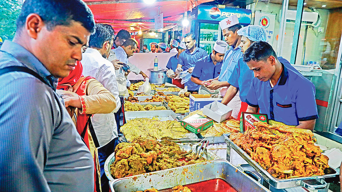 রেস্তোরাঁর ভেতরে এখনো ইফতার আড্ডা জমেনি, বাইরে ক্রেতাদের ভিড়। গতকাল রাজধানীর সাতমসজিদ সড়কের একটি দোকানে। ছবি: প্রথম আলো