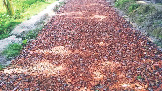 জামালপুর সদরের বিনন্দরপাড়া-নাকাটি বাজার সড়কে পড়ে আছে ইট ও খোয়া। গত মঙ্গলবার কুটামনি গ্রামে।  ছবি: প্রথম আলো