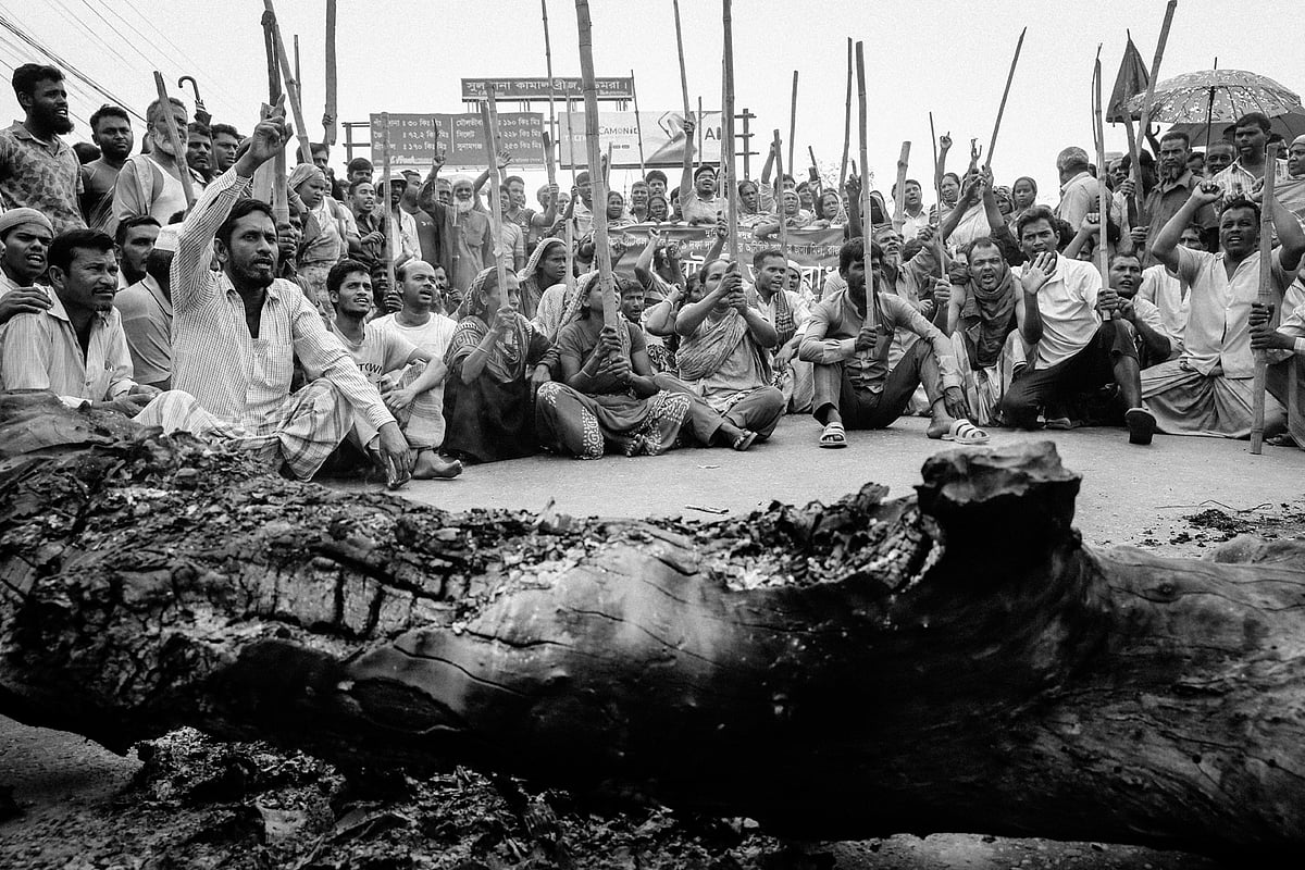 সুলতানা কামাল সেতুর মুখে গাছের গুঁড়ি ফেলে অবস্থান নিয়েছেন শ্রমিকেরা।