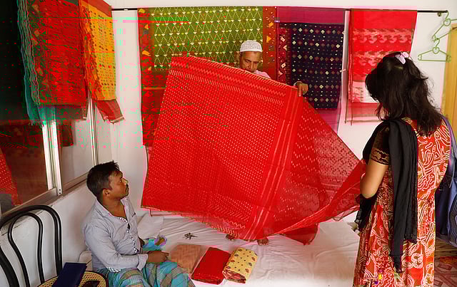 জামদানিপল্লির একটি দোকানে শাড়ি দেখছেন এক ক্রেতা। ঢাকাসহ আশপাশ এলাকার অনেক ব্যবসায়ী এখানে নিয়মিত আসেন পাইকারি দরে শাড়ি কিনতে। প্রতি শুক্রবার বসা হাটেও থাকে জমজমাট ব্যবসা।