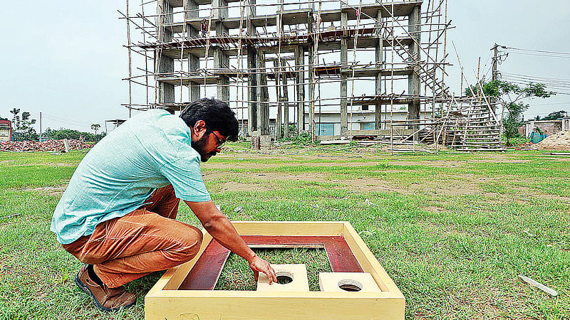 শহীদ মিনারে মা বর্ণমালা স্থাপনের কাজ করছেন স্থপতি রাজন দাস। সিলেটের লিডিং ইউনিভার্সিটি ক্যাম্পাসে গত বৃহস্পতিবার দুপুরে।  ছবি: প্রথম আলো