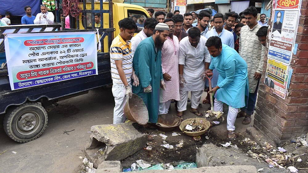 নিজ দলের নেতা-কর্মীদের নিয়ে দিনাজপুর পৌর এলাকার ময়লা আবর্জনা পরিষ্কার অভিযানে নেমেছেন জেলা স্বেচ্ছাসেবক লীগের সভাপতি আবু ইবনে রজব। ছবি: প্রথম আলো