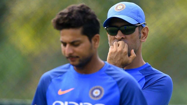 কুলদ্বীপ যাদব ও মহেন্দ্র সিং ধোনি। ছবি: এএফপি