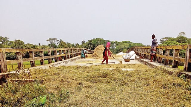 যানবাহন চলাচল নেই। সেতুর ওপর ধান শুকাচ্ছেন এলাকাবাসী।  প্রথম আলো