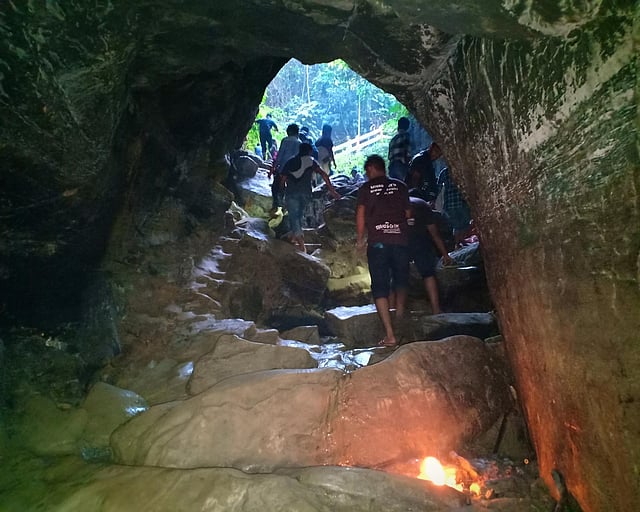 গুহার ভেতর পর্যটকদের ফেলে দেওয়া মশালে আগুন জ্বলছে। ছবি: জয়ন্তী দেওয়ান