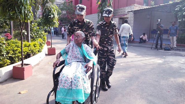 এক বৃদ্ধ ভোটারকে কলকাতা বয়েজ স্কুল কেন্দ্রে নিয়ে যাচ্ছে কেন্দ্রীয় বাহিনী। ছবি: ভাস্কর মুখার্জি
