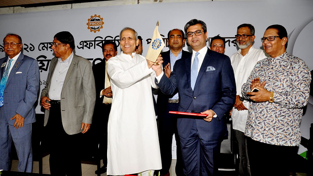 নতুন সভাপতি শেখ ফজলে ফাহিমের হাতে এফবিসিসিআইয়ের পতাকা তুলে দিচ্ছেন বিদায়ী সভাপতি শফিউল ইসলাম মহিউদ্দিন। আজ রাজধানীর ফেডারেশন ভবনে। ছবি: এফবিসিসিআইয়ের সৌজন্যে