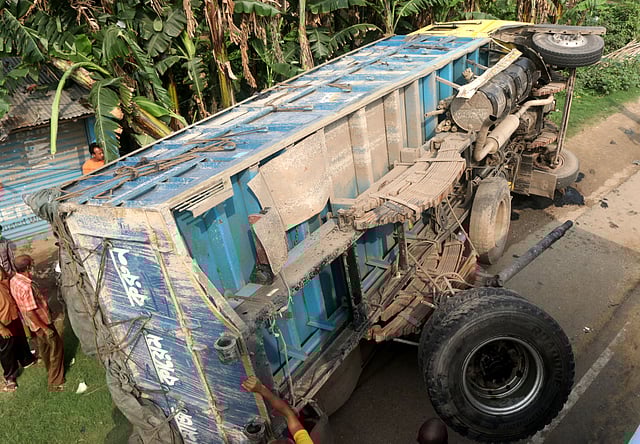 ট্রাকটি রাস্তার পাশে উল্টে আছে।