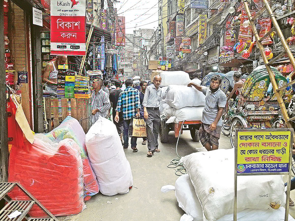 পণ্য কেনার পর তা বোঝাই করা হচ্ছে ঠেলাগাড়িতে। রোববার চকবাজারে।  প্রথম আলো