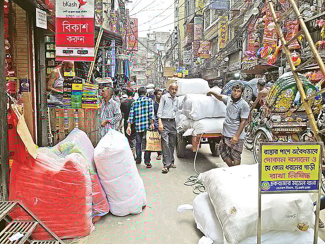 পণ্য কেনার পর তা বোঝাই করা হচ্ছে ঠেলাগাড়িতে। রোববার চকবাজারে।  প্রথম আলো
