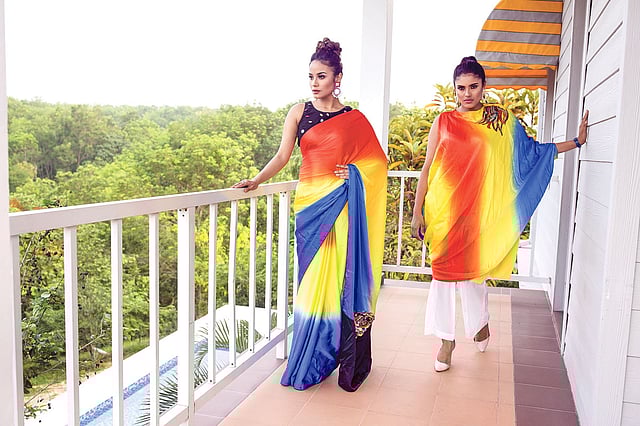 উজ্জ্বল রংগুলো মনে করিয়ে দিচ্ছে—সামনেই উৎসব। সিল্কের শাড়ি এবং ওয়ান শোল্ডার বেলুন ড্রেসটিতে টাই-ডাইয়ের মাধ্যমে তিন থেকে চারটি রং আনা হয়েছে। পুরো পোশাকে নয়, বরং হঠাৎ এক জায়গায় ফুটে উঠেছে জমকালো কাজ। এতেই যেন চলে এসেছে ভিন্নতা। পোশাক: হুমায়রা খান