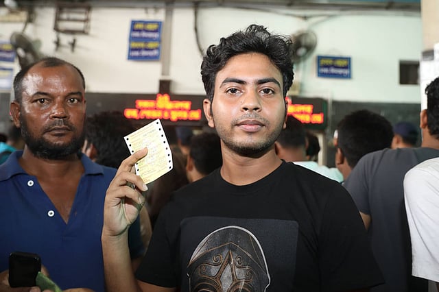 ঈদুল ফিতর উপলক্ষে ট্রেনের অগ্রিম টিকিট হাতে পেয়ে তা দেখাচ্ছেন এক তরুণ। কমলাপুর রেলওয়ে স্টেশন, ঢাকা, ২২ মে। ছবি: আবদুস সালাম