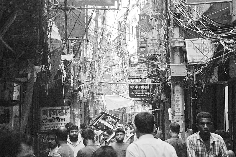 হোসিয়ারির প্রধান কেন্দ্র নারায়ণগঞ্জের নয়ামাটির সরু রাস্তার দুই পাশের বাড়ি ঘেঁষে বিদ্যুৎসহ বিভিন্ন তারের জটলা। এর মধ্যে চলছে বেচাকেনা।  ছবি: ​দিনার মাহমুদ