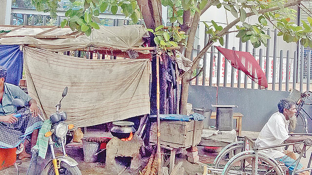 ফুটপাত দখল করে গড়ে তোলা হয়েছে হোটেল। বটগাছের গোড়ায় জ্বলছে হোটেলের চুলা। গতকাল রাজশাহী নগরের সাগরপাড়া বটতলায়।  প্রথম আলো