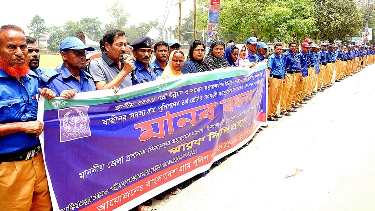চতুর্থ শ্রেণির সরকারি কর্মচারীদের মতো জাতীয় বেতন স্কেলের দাবিতে মানববন্ধন কর্মসূচি পালন করেন বাংলাদেশ গ্রাম পুলিশ কর্মচারী ইউনিয়নের নেতারা। দিনাজপুর, ২৬ মে। ছবি: সংগৃহীত