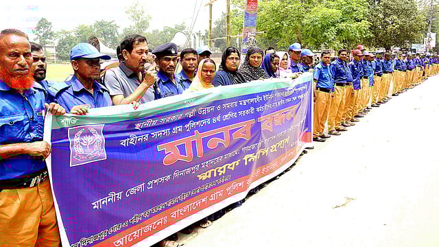 চতুর্থ শ্রেণির সরকারি কর্মচারীদের মতো জাতীয় বেতন স্কেলের দাবিতে মানববন্ধন কর্মসূচি পালন করেন বাংলাদেশ গ্রাম পুলিশ কর্মচারী ইউনিয়নের নেতারা। দিনাজপুর, ২৬ মে। ছবি: সংগৃহীত