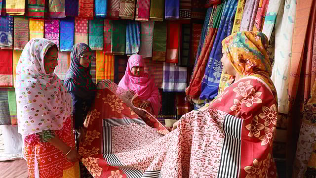 টাঙ্গাইলের তাঁতের শাড়ি দেখছেন ক্রেতারা।